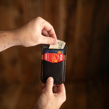 Load image into Gallery viewer, black and buck brown minimalist wallet with cards and money sliding out
